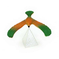 Balancing bird ornament with orange body, green wings, and a white folded base