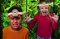 Two kids wearing T-Rex head torches, brown dino faces, orange patterned headbands
