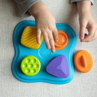 Lidzy sensory toy with blue base and snap-on ring pieces in orange, green, purple, yellow