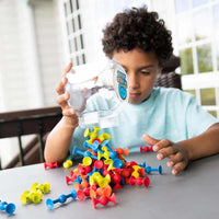 Mini Squigz suction building pieces with blue, red, and yellow parts on a tabletop