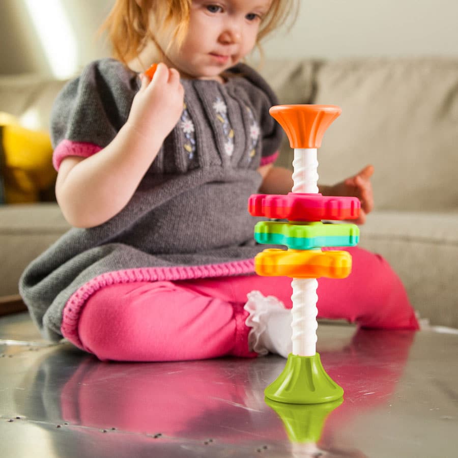 Stacking spinner toy with a white pole and orange-green-red-yellow ring layers