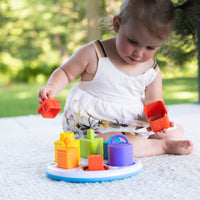 Colorful Plugzy shape sorter toy with snap-on blocks on a round blue base