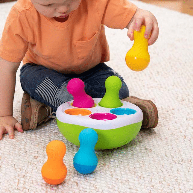Spinny Pins toy with green base and colorful spinning pegs for toddlers