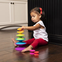 Child playing with colorful stacking ring toy with interlocking discs