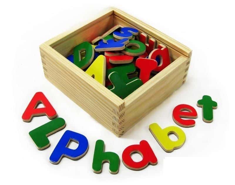 Magnetic letter pieces in a wooden tray, colorful alphabet shapes