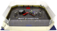 Battle arena playset view with clear walls, yellow track, and two robot toys