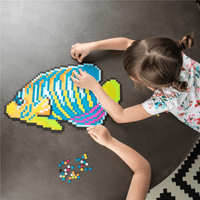 Under the sea pixel art set: child assembles a blue and yellow fish design.