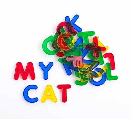 Transparent colorful letter pieces spelling “MY CAT” with rounded edges and cutouts
