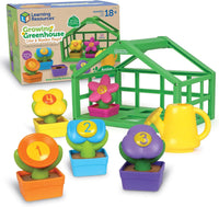 Assembled greenhouse playset with numbered flower pots and yellow watering can, plus box