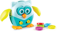 Light blue owl fine-motor toy with yellow wings and teal gear eyes, with coins