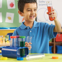 Jumbo test tube set with blue stand, clear tubes, colored caps held by a child