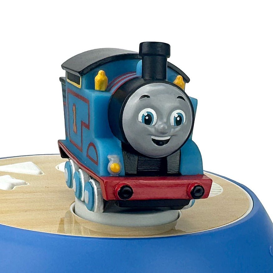 Blue toy train engine with smiling face, red base, on a circular track.