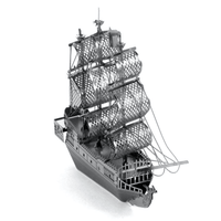 Metal model sailing ship with perforated sail panels and raised masts