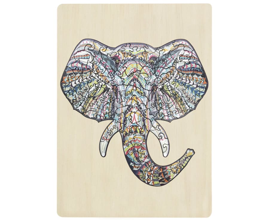 Wooden jigsaw puzzle elephant with colorful patterned pieces on a light board