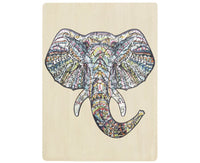 Wooden jigsaw puzzle elephant with colorful patterned pieces on a light board