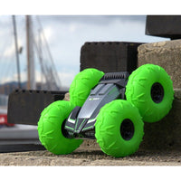 Neon green RC monster truck with gray body, black grille, oversized treaded wheels