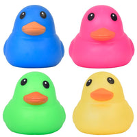 Four squishy duck sensory toys in blue, pink, green, and yellow with orange beaks